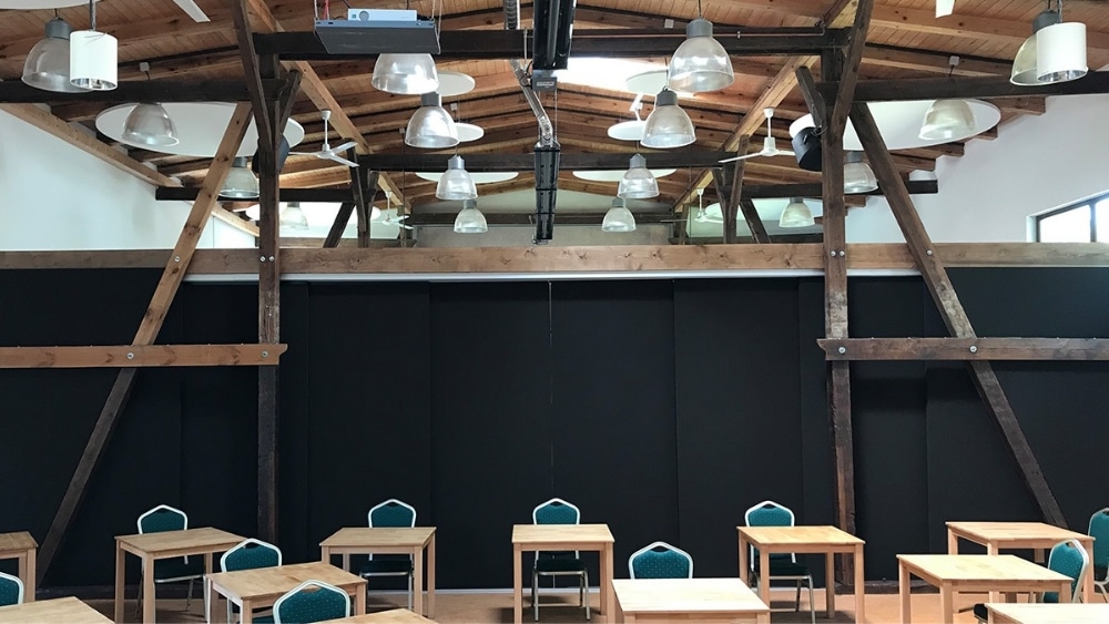 Innenraum mit Baustoffen, Holzdecke und Schulungstischen, Wego Systembaustoffe.